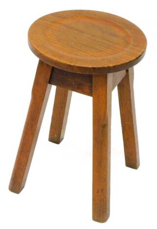 A small Arts and Crafts style stool, with a circular dished top, on chamfered legs, 30cm dia.