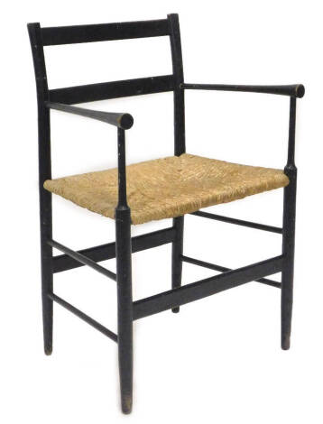 An ebonised William Morris type open arm chair, with rush seat.