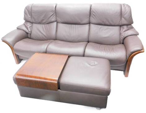 A Stressless dark brown leather three seater sofa, with show frame ends and supports, and a double foot stool.