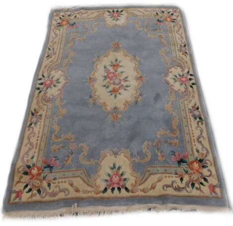 A Chinese cut wool carpet, with a central beige floral cartouche on a powder blue ground with one wide border, 233cm x 166cm.