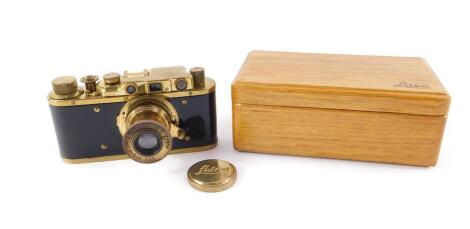 A Leica II replica camera No 215463, possibly Zorki, with a gilt metal and faux wood casing, with a Leitz Elmar F=5cm 1:35 lens, No 015926, wooden cased. (2)