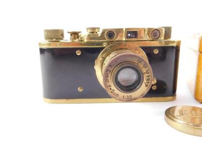 A Leica II replica camera No 215463, possibly Zorki, with a gilt metal and faux wood casing, with a Leitz Elmar F=5cm 1:35 lens, No 015926, wooden cased. (2) - 2