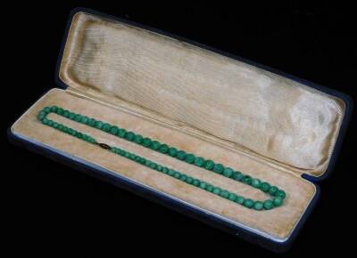 A green Jade necklace, with graduated orb sections on a plain string, with gilt coloured clasp, in fitted case with associated letter from Sotheby's suggesting it can be put into one of their sales on the 3rd October 1969, 46cm L, in original outer case.