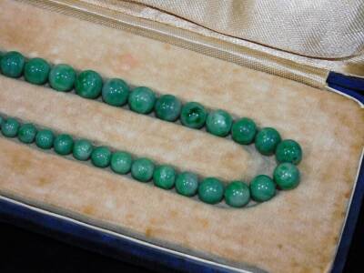 A green Jade necklace, with graduated orb sections on a plain string, with gilt coloured clasp, in fitted case with associated letter from Sotheby's suggesting it can be put into one of their sales on the 3rd October 1969, 46cm L, in original outer case. - 2