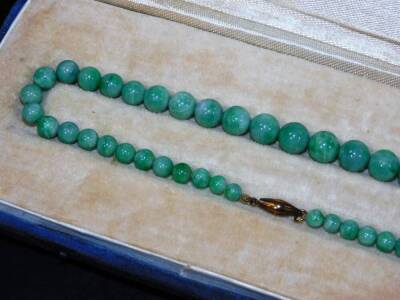 A green Jade necklace, with graduated orb sections on a plain string, with gilt coloured clasp, in fitted case with associated letter from Sotheby's suggesting it can be put into one of their sales on the 3rd October 1969, 46cm L, in original outer case. - 3