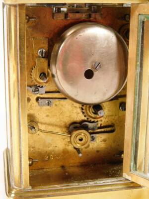 An early 20thC brass carriage clock, of rectangular form, with a five sectional glass case and swing handle, with 5cm W Roman numeric dial and subsidiary Arabic second hand, with an open keywind movement, striking on a bell, with plain back plate numbered - 5