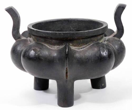 A Chinese bronze censer, of bombe form, with raised body, plain neck and shaped handles on triple feet, unmarked probably Qing period, 16cm H.