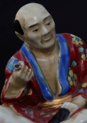 An early 20th Japanese pottery figure, of a gentleman seated in flowing robes, florally decorated predominately in yellow, blue and red, on a circular foot, impressed mark JAPAN beneath, 9cm H. - 5