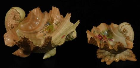 An early 20thC Royal Worcester blush ivory shell shaped dish, 1917, handpainted with posies, on a shaped base, G234, marked beneath, 7cm H, and a larger shell shaped dish, 1903. (2, AF)