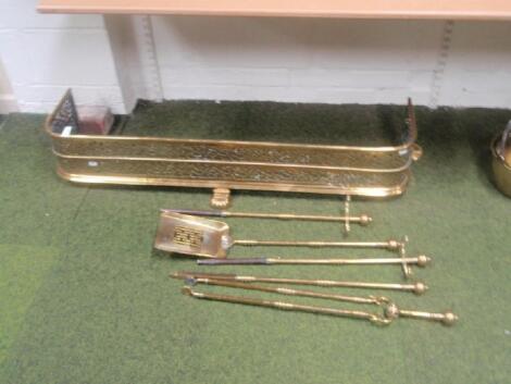 A Victorian pierced brass fender with integral stanchions and matching