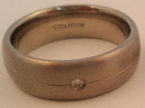 A titanium wedding band set with a small diamond
