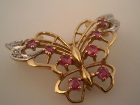 A filigree butterfly brooch set with small pale rubies and tiny diamonds