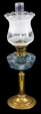 An early 20thC oil lamp, with clear chimney, frosted and clear glass shade, and a moulded glass reservoir, on a plain cylindrical brass stem and stepped circular foot, 66cm H.