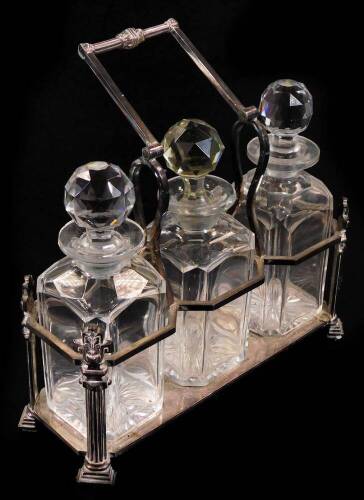 An Edwardian Aesthetic style silver plated three sectional tantalus, with cut glass bottles, each of square shouldered form, with shaped stoppers, on an angular base, 32cm W.