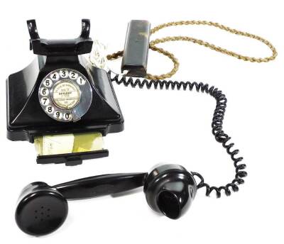 A 20thC black Bakelite telephone, with shaped receiver attached by a wire, with articulated front chrome dial and drawer, 20cm W. - 2