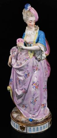 A continental porcelain figure of a lady, polychrome decorated and dressed in finery, on shaped circular base, predominately in blue, pink and yellow, cross sword mark beneath, 37cm H.