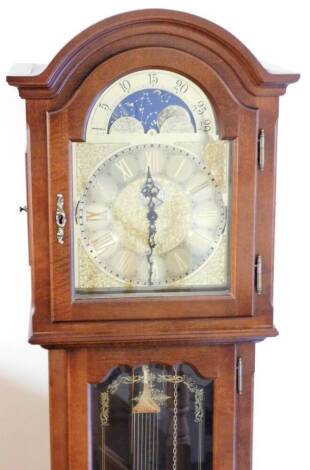 A modern longcase clock, with arched hood raised above a glazed door, on bracket feet, with fancy arched moon rolling 26cm W dial, with raised scroll spandrels and subsidiary Arabic second hand, chiming on the hour, on eight bells, 195cm H.