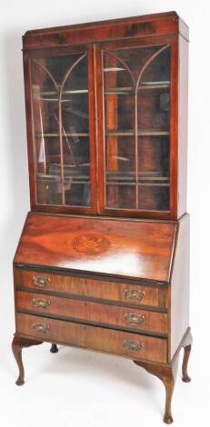 An Edwardian mahogany stained bureau bookcase, the upper section with a fixed cornice raised above two astragal glazed doors, the subsection with an oval patera to the fall, with fitted interior above three long drawers, on compressed cabriole pad feet, 1