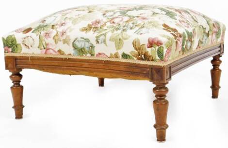 An early 20thC stool, overstuffed in floral material, on turned legs, 45cm H, 70cm W, 68cm D.