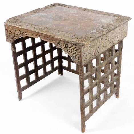 An unusual 19thC hardwood folding table, the square top heavily carved with various motifs, with further carving to the frieze, on an articulated pierced base, with two legs and a loose leg, 82cm W. (AF)