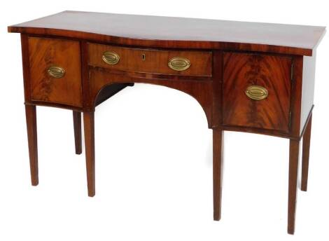 A late Victorian mahogany serpentine sideboard, with a central drawer with plate back handles, flanked by cupboards on square tapering legs, 87cm H, 148cm W, 58cm D.