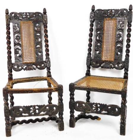 A pair of 19thC oak stained Carolean chairs, each with high backs, decorated with pierced scrolls and cherubs with acorn finials, with bergere sections to the back and seats, on turned legs joined by a barleytwist H stretcher, 115cm H. (2, profusely dama