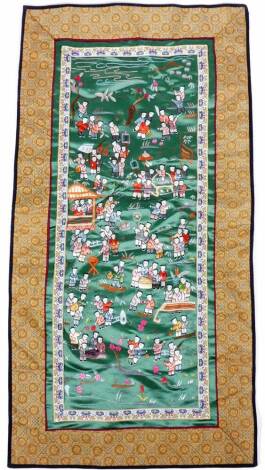 Chinese Qing School. Many children in colours, in a landscape, on material ground with outer geometric floral border, 63cm x 33cm.