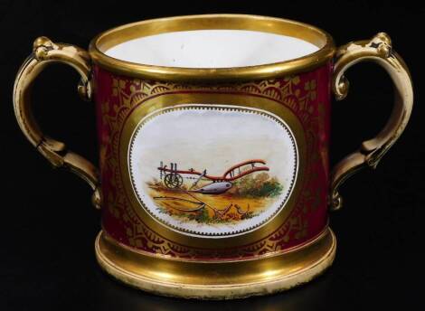 A Coalport two handled loving cup, decorated with a plough within a claret ground, the reverse with verse, c1860, 12cm H. (handle AF)