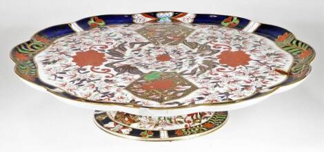 A 19thC English porcelain Imari comport, of large proportion, the floral top profusely decorated with birds and flowers, predominately in red, blue and green with gilt highlights, on a compressed stem and circular foot, unmarked, 40cm W.