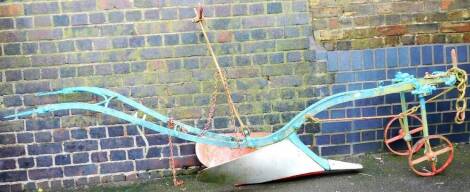 A early 20thC iron horse plough, in blue and red with shaped handles, with anchor shaped adjustor and front wheels, 130cm H.