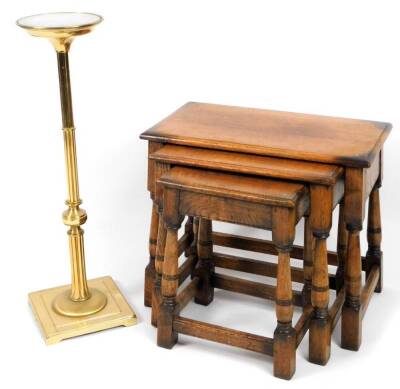 A nest of three oak tables, in the manner of Titchmarsh & Goodwin, each of rectangular form, on turned legs with block feet, the largest 52cm H, 65cm W, 34cm D and a brass stand on turned stem and square foot.