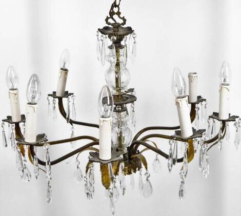 A late 20thC cut glass and metal electrolier, with a floral mount raised above glass sections surrounded by eight acanthus leaves and scroll sconces with candles and glass bulbs, with cut glass droppers, 45cm H.