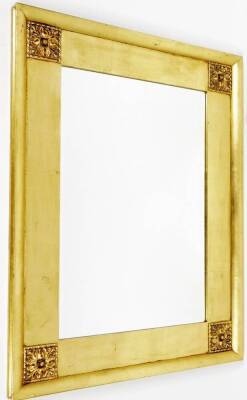 A late 20thC gilt wood mirror, of rectangular form, with raised floral spandrels and bevel glass, 77cm x 100cm.