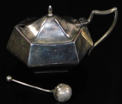 A George VI silver mustard pot, of hexagonal form, with ear shaped handle and associated spoon, Birmingham 1945, 6cm H, 1.4oz.