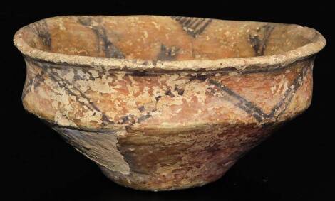 A red terracotta bowl, with black triangular decoration, possibly early Greek, hand thrown, 17cm Dia.