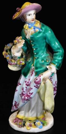 A mid 18thC Bow porcelain figure, of lady in standing pose wearing floral dress holding a basket of flowers, on a circular foot, with accompanying letter and B & T Thorn & Sons label, 15cm H.