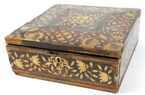 A 17thC Indo Portuguese tortoiseshell and mother of pearl box, of square form, profusely decorated with an arrangement of scrolls and flowers, with a central floral and leaf emblem and fully inlaid inner with interior strap work supports, 15cm H, 39cm W,