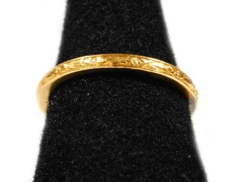 A wedding band, with floral scroll decoration to gold coloured outer band, with white metal centre stamped 22ct, possibly two rings joined.