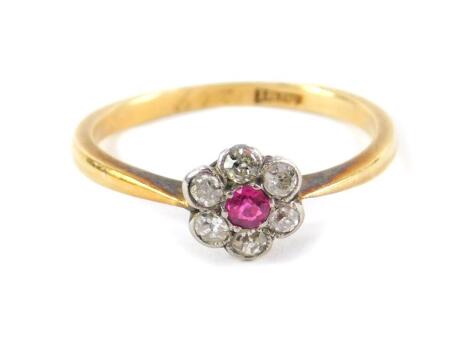 A ruby and diamond flower head ring, set in yellow metal stamped 18ct, size K, 1.9g.