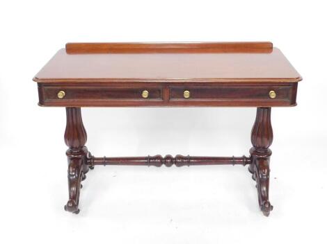 A Victorian mahogany side table, with two frieze drawers raised on turned fluted columns over cabriole legs, on brass casters, united by a turned stretcher 80cm H, 122cm W, 55cm D.