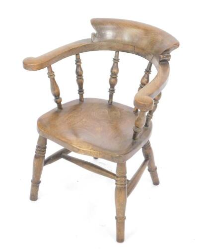 A 19thC oak and elm child's bow chair, with solid saddle seat, raised on ring turned legs united by a H frame stretcher.