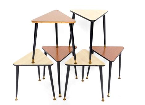 A set of six 1950's triangular occasional tables, with two different coloured laminate tops, raised on turned ebonised legs, brass capped, 37cm W, 41cm D.