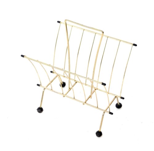 A 1960's Atomic two division metal magazine rack, raised on four rubber ball feet, 42cm H, 34cm W, 26cm D.