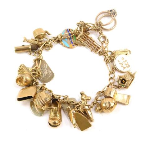 A 9ct gold oval and curb link charm bracelet, on a bolt ring clasp with safety chain and twenty five charms as fitted, two being gold plated cufflink sections, 33.1g all in.