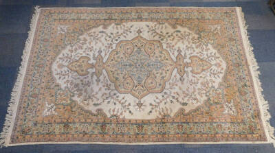 A Tabriz rug, decorated with a central floral medallion, within a floral ground and borders, against a cream ground, 298cm x 187cm.