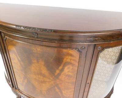 An early 20thC mahogany bow front sideboard, the central door opening to reveal two shelves, flanked by two glazed doors, opening to reveal two glass shelves, fabric backed, raised on cabriole legs and ball and claw feet, 100cm H, 136.5cm W, 53cm D. - 3