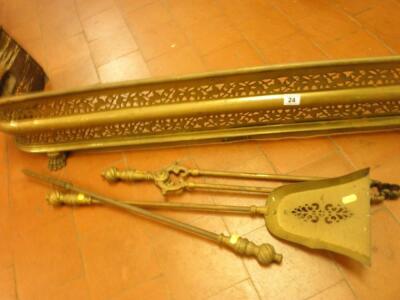 A XIX century pierced brass fender and a set of three brass fire