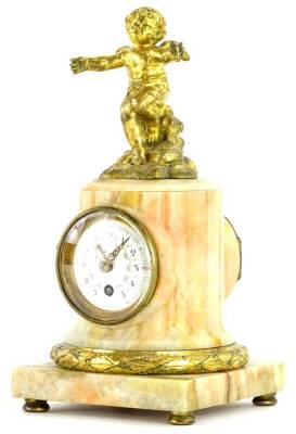 A French pink onyx and gilt metal mantel timepiece, mounted with a putto, the column shaped case applied with a white enamel dial decorated with floral swags etc., on a square plinth with bun feet, 22cm H.