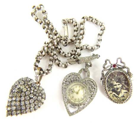 Three items of Victorian and later jewellery, comprising a Victorian portrait brooch, with marcasite border and red paste stone set bow top, in unmarked silver gilt back, 4cm x 3cm, a paste stone set heart pendant, on brass back, on a silver plated chain,