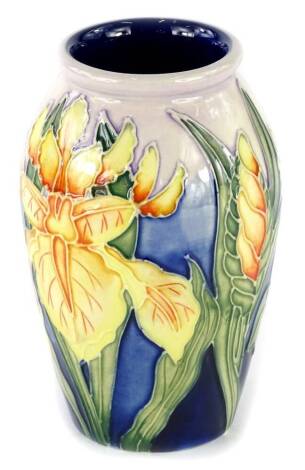 A Moorcroft pottery bullet shaped vase, decorated with iris type flowers on a blue ground, impressed marks and handwritten marks to underside, copyrighted for 2000, 11cm H.